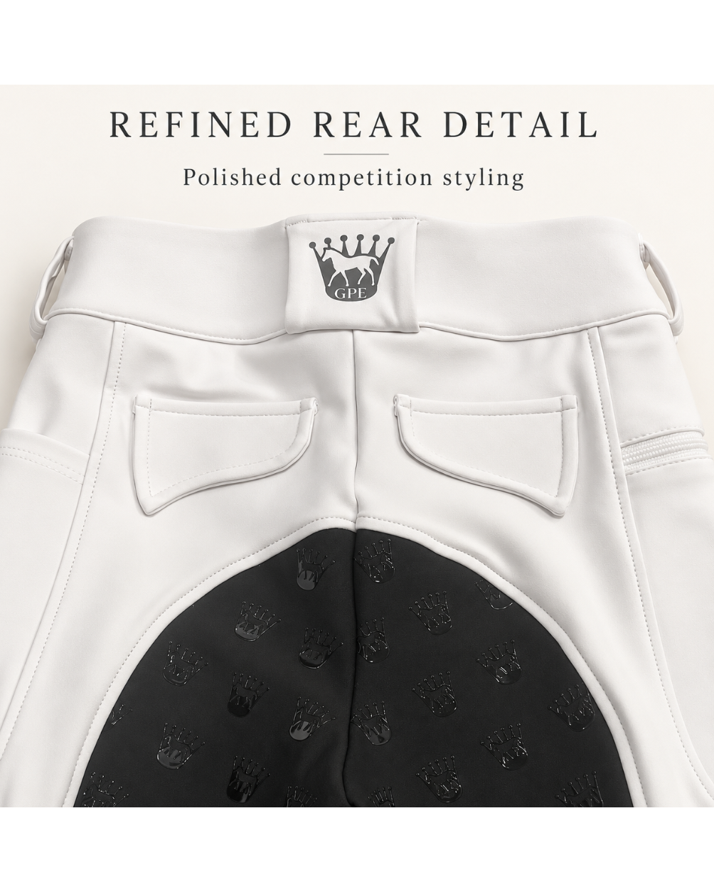 Close-up of the back of white equestrian riding shorts with a black patterned rear panel, two back pockets, and a small crown logo patch at the waistband. Text at the top reads 'REFINED REAR DETAIL' and 'Polished competition styling.