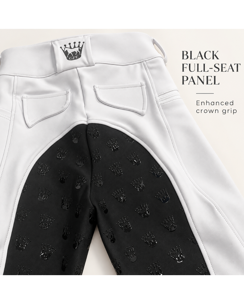 Close-up of the back waistband and seat area of riding breeches, showing a white outer panel and a black inner full-seat panel with an allover embossed crown pattern. Text on the right reads 'BLACK FULL-SEAT PANEL' and 'Enhanced crown grip.